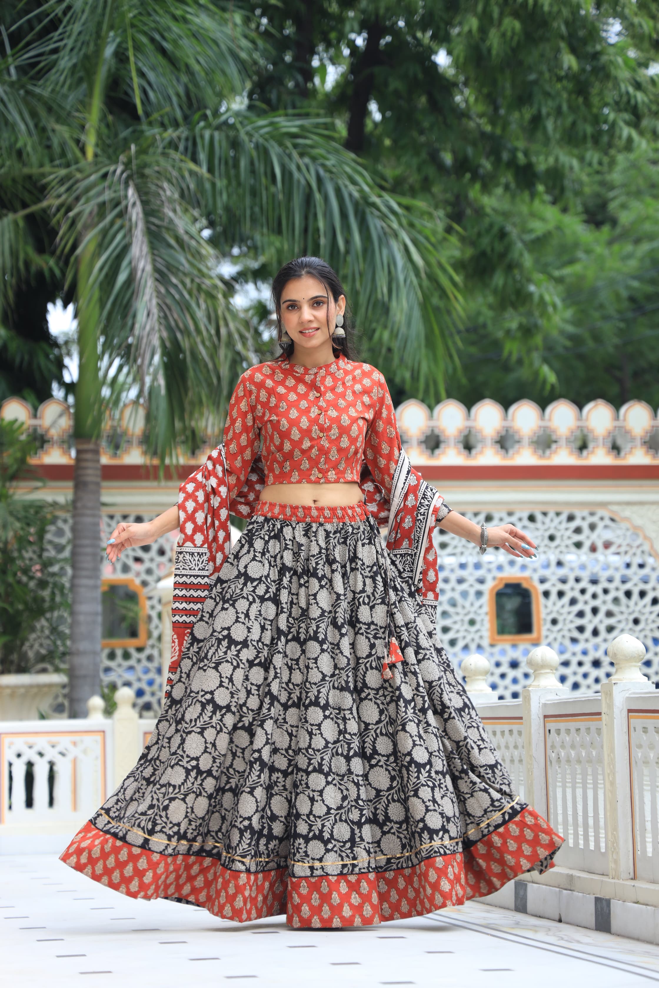 Majestic Red + Black Bagru Hand Printed Couple Set – Vibrant Chaniya Choli with Multicolored flowerd Skirt & Elegant Mulmul Dupatta | Matching Regal Men’s Kurta with Classic White Payzama