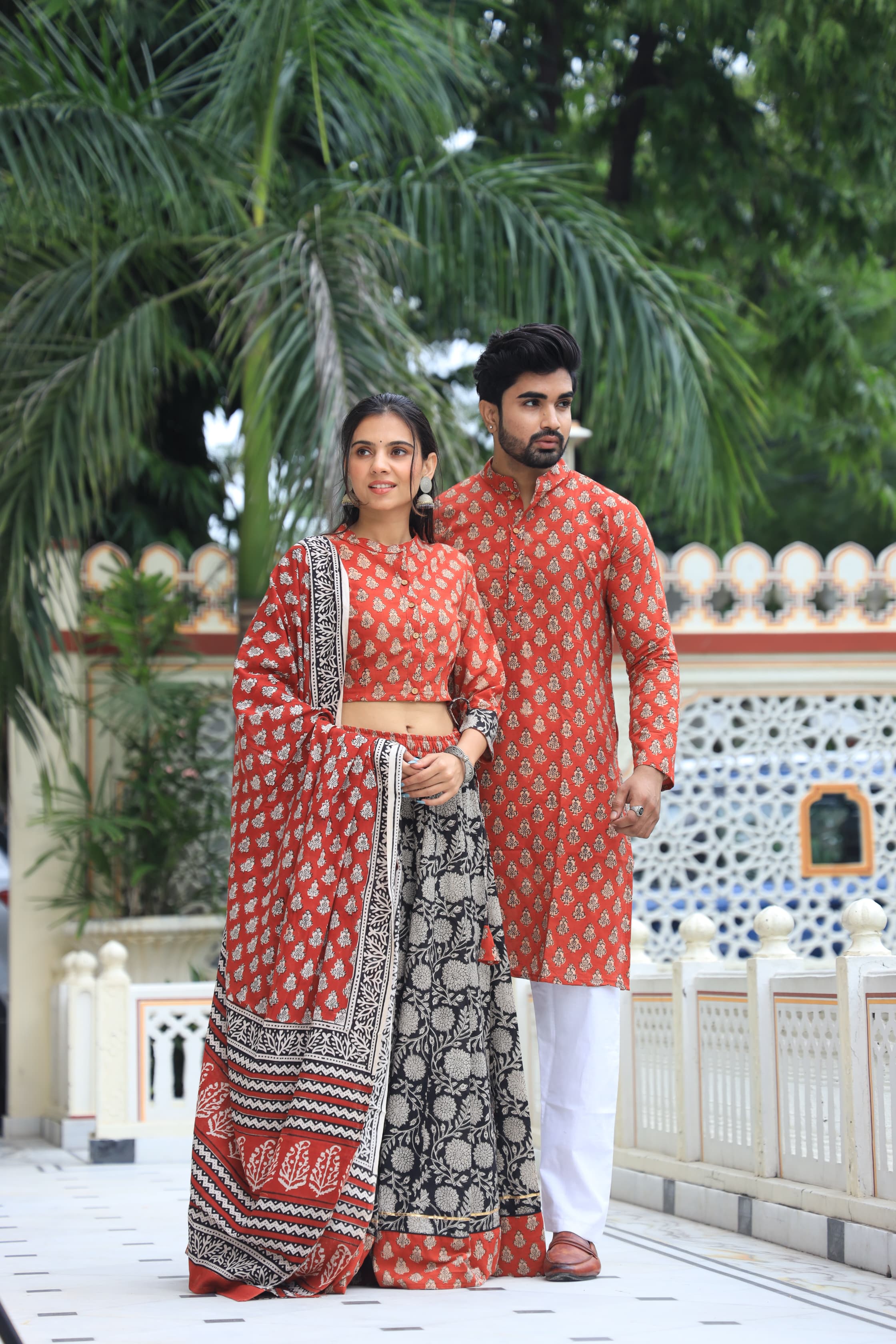 Majestic Red + Black Bagru Hand Printed Couple Set – Vibrant Chaniya Choli with Multicolored flowerd Skirt & Elegant Mulmul Dupatta | Matching Regal Men’s Kurta with Classic White Payzama