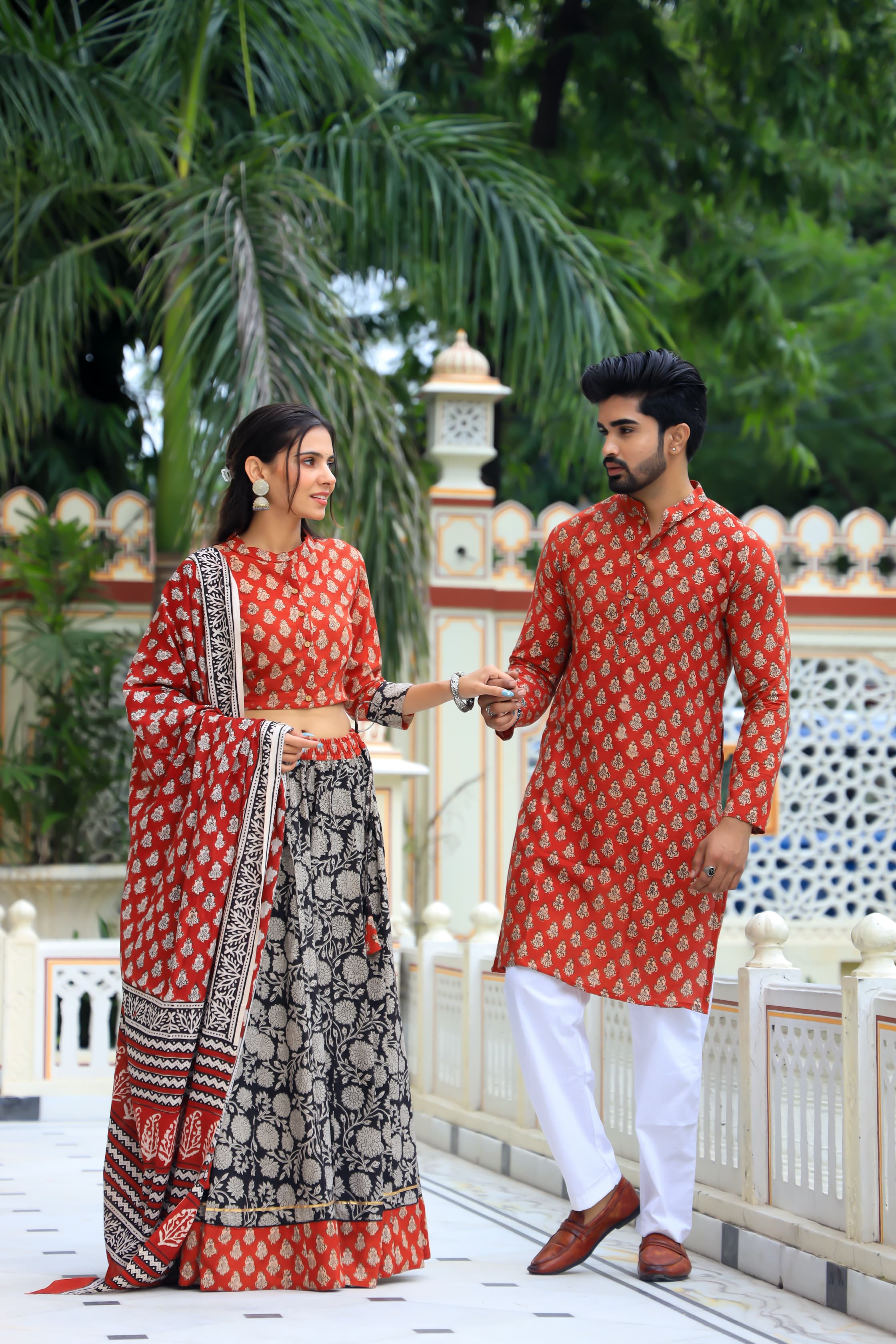 Majestic Red + Black Bagru Hand Printed Couple Set – Vibrant Chaniya Choli with Multicolored flowerd Skirt & Elegant Mulmul Dupatta | Matching Regal Men’s Kurta with Classic White Payzama